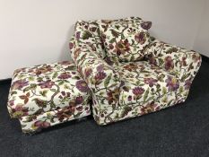 An over sized armchair in a floral fabric with matching footstool