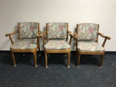 A set of three walnut scroll arm, armchairs,