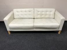 Two contemporary white leather settees on beach legs