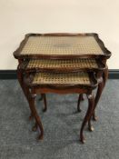 A nest of three mahogany bergere topped tables