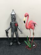 A metal figure of the tin man together with a metal flamingo