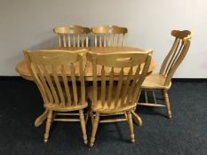 A pine extending kitchen table together with a set of five high backed chairs