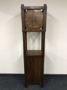 An American style Arts & Crafts oak clock, with pendulum and cupboard base,