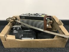 A box containing a transistor radio, drawing instruments, a coffee grinder, a brass handled sword,