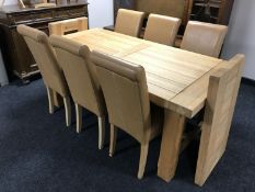 A contemporary pine dining table with extending leaves and a set of six tan leather high-backed