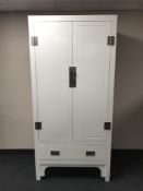 A white lacquered oriental style wardrobe fitted a drawer