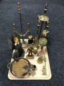 A tray of two brass companion sets, brass and onyx candle holder, brass figure,