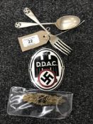 A fork and spoon bearing swastika emblem and two reproduction German badges
