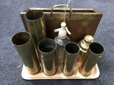 A tray containing an embossed brass magazine rack together with five ammunition shell casings,