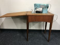 A Singer electric sewing machine and teak table