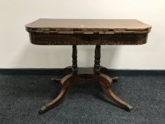 A Victorian inlaid mahogany turnover top tea table on a four way pedestal