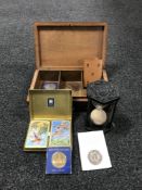 A carved Indian trinket box with key, commemorative crowns, hour glass on stand,