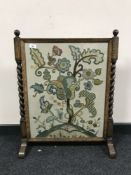 An early twentieth century oak barley twist tapestry fire screen