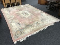 A large Chinese fringed embossed carpet on pink ground