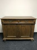 An early 20th century oak double door sideboard on bun feet