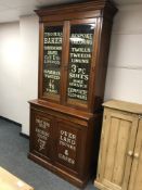 A 19th century and later mahogany glazed bookcase with advertising decoration,