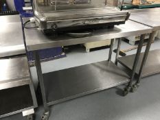 A stainless steel two tier preparation table, on wheels,