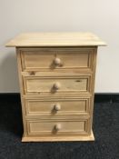 An unfinished reclaimed pine four drawer bedside chest