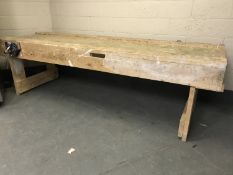 A large double sided woodwork bench, length 298cm, fitted with two bench vice,