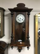 A walnut cased Vienna wall clock with enamelled dial
