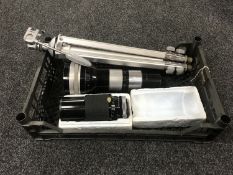 A basket containing a pyramid camera tripod together with two telescopic camera lenses