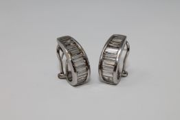 A pair of 18ct white gold diamond earrings, each set with 12 graduated baguette-cut stones,