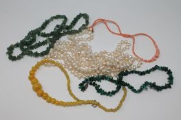 A group of five necklaces to include a large pearl example, jade, coral,