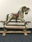 An antique hand painted rocking horse on stand CONDITION REPORT: In distressed