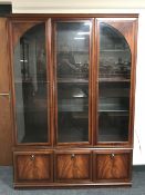A triple door display cabinet fitted cupboards beneath