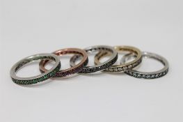 A suite, or stack, of five 9ct gold eternity rings, each set rubies, sapphires, emeralds,