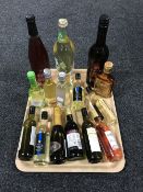 A tray of various alcohols including Napolean Brandy, Harvey's Sherry, Merlot,