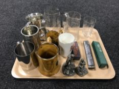 Two early twentieth century etched glass jugs together with a beaker, three harmonicas,