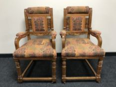 A pair of early twentieth century carved oak armchairs upholstered in a multi coloured fabric
