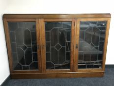 An early 20th century mahogany triple door bookcase with leaded glass doors