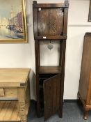 An American style Arts & Crafts oak clock, with pendulum and cupboard base,