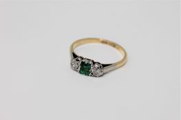 An 18ct gold emerald and diamond three stone ring