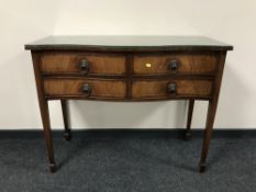 An inlaid mahogany serpentine fronted four drawer serving table with lion mask handles