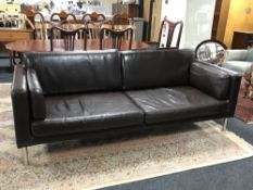 A contemporary brown leather settee on metal legs