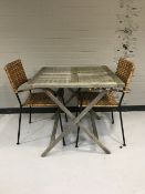 A folding teak garden table together with two wicker and metal garden chairs