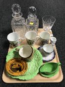 A tray containing a pair of cut glass decanters with stoppers, royal commemorative china,