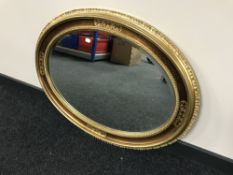 A decorative oval gilt framed bevel edged mirror
