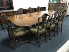 A mahogany triple pedestal dining table with two further extension leaves and eight shield back