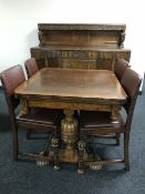 An early twentieth century six piece carved oak dining room suite comprising of buffet back