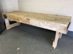 A large double sided woodwork bench, length 298cm, fitted with two bench vice,