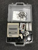 A Super Nintendo Entertainment System with controllers and five games in a carry case