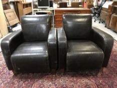 A pair of brown leather tub chairs