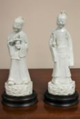 A pair of antique Chinese blanc de chine figures, on later hardwood stands,