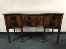 A inlaid mahogany serpentine fronted sideboard with lion mask handles