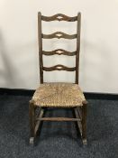 An antique pine rush seated rocking chair