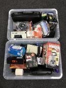 Two boxes containing boxed electricals, including a dual beam laser projector, timer sockets,